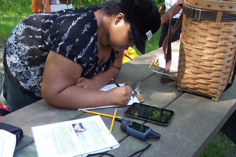A citizen scientist writing field notes outdoors in Cuyahoga Valley National Park